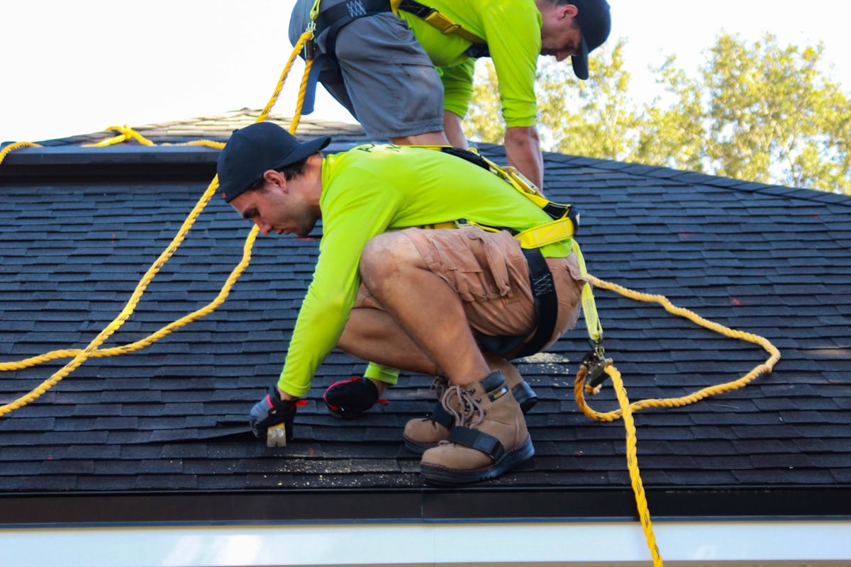Roofing crew completing installation after a successful roofing sales process and signed contract