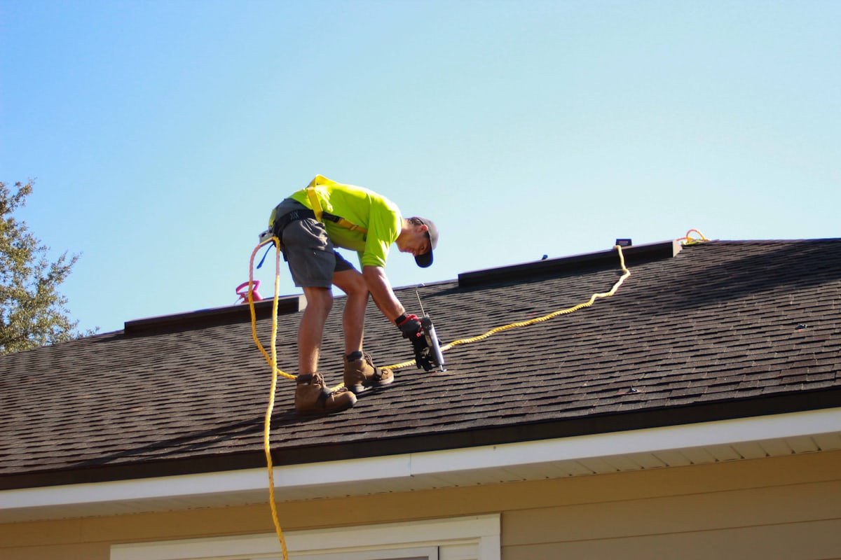 Roofing crew installing shingles on residential home — scheduling and dispatching managed by roofing CRM software