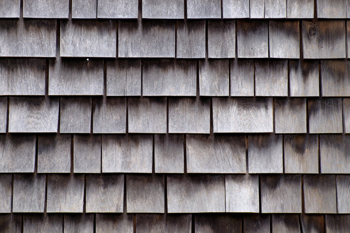 Roofing contractor measuring and calculating roofing squares and shingle bundles for a residential project