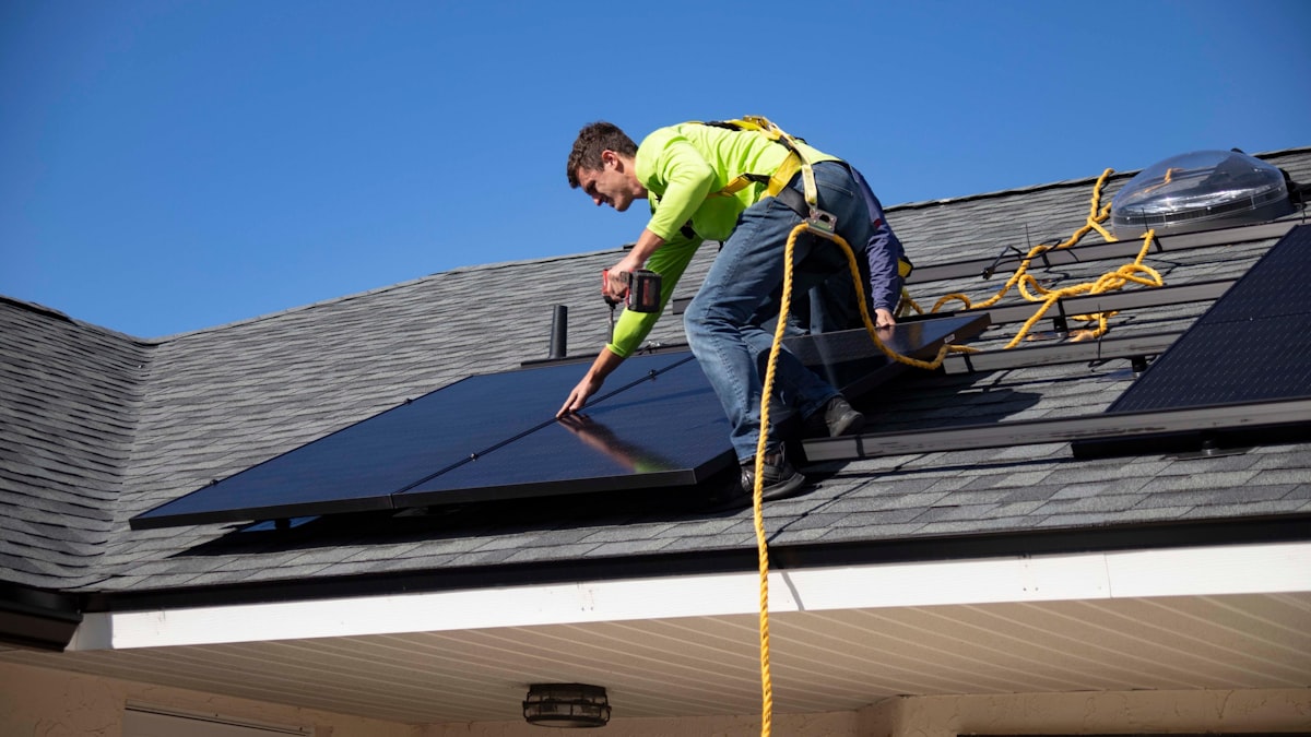 Solar proposal software in use — rep reviewing solar quotes and system options with homeowner during consultation