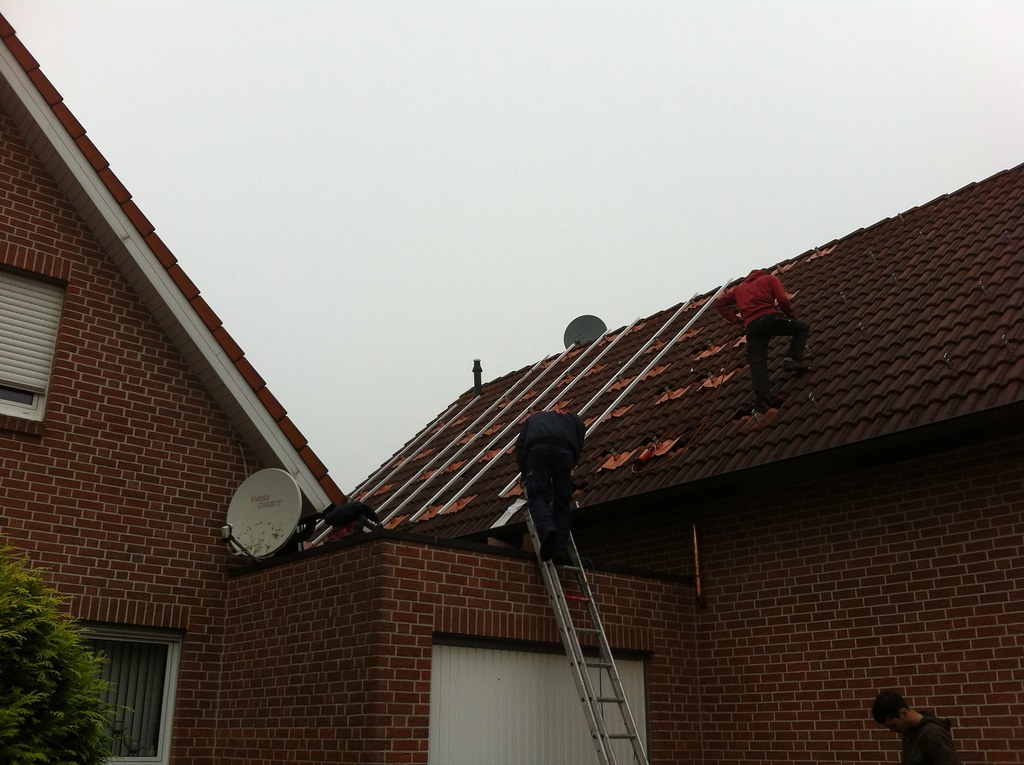 Solar panel installation in progress — PV system design being realized on residential rooftop lattice framework