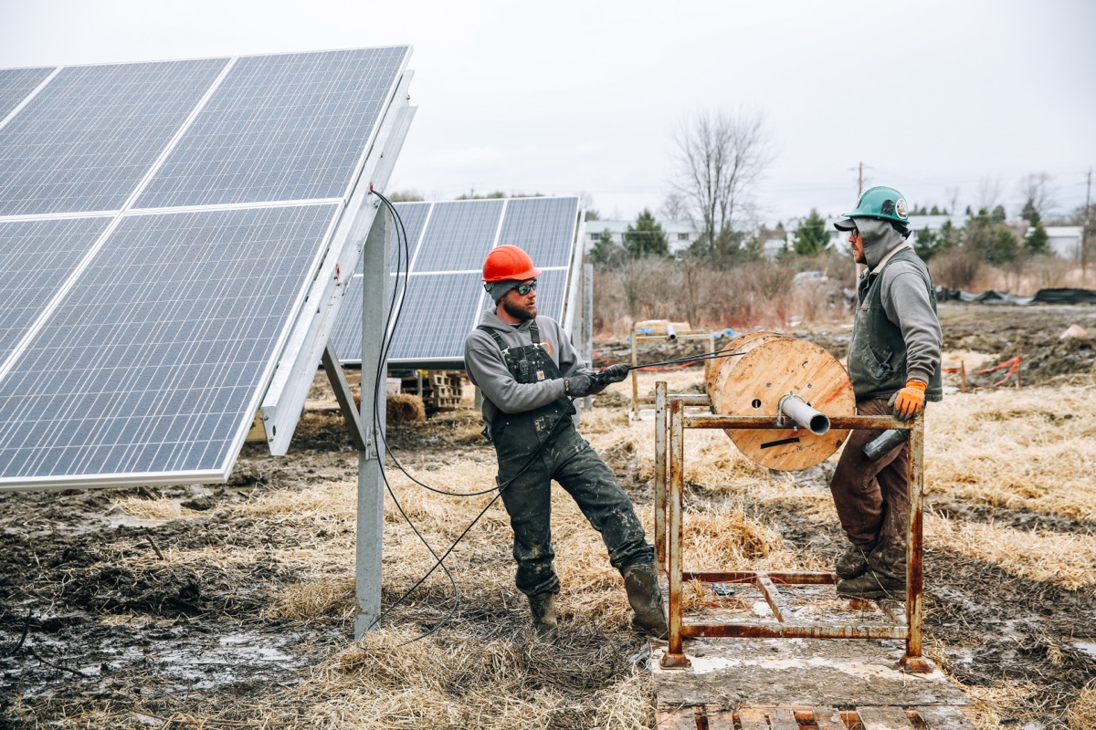 Best solar installer software — technicians mounting solar panels on residential rooftop